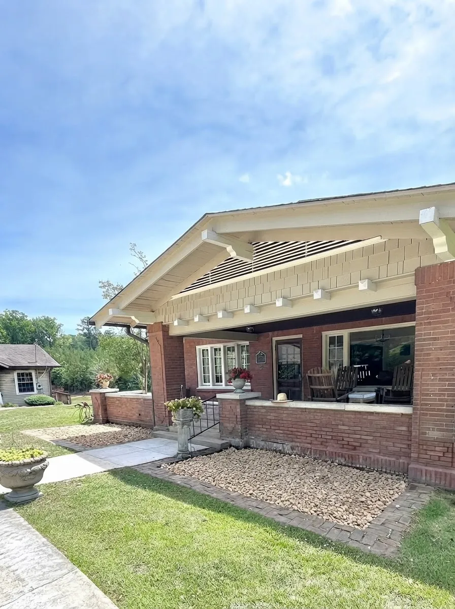 The same brick porch cleaned off with rocking chairs and planters