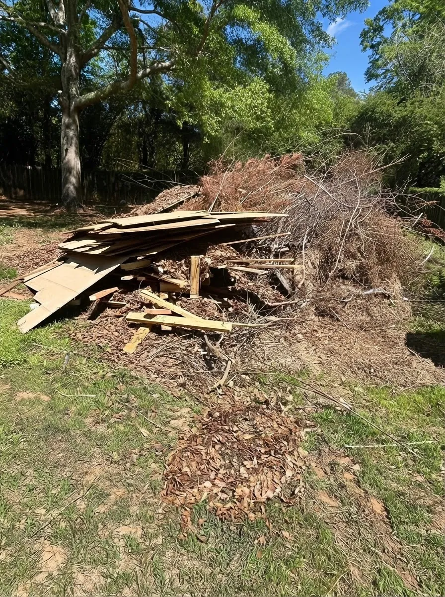 Large pile of wood and brush debris stacked in a yard